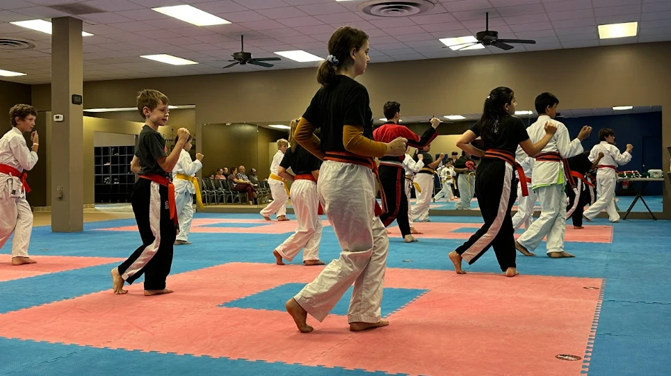 Children practicing dynamic footwork and karate drills on mats in Greece, NY.