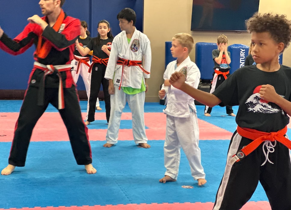 Karate instructor leading youth students in ready stances at Murray's Martial Arts.