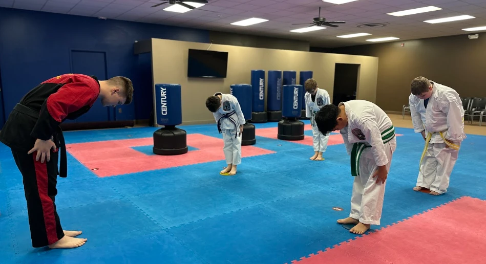 Students and instructor practicing traditional bowing etiquette at Greece dojo.